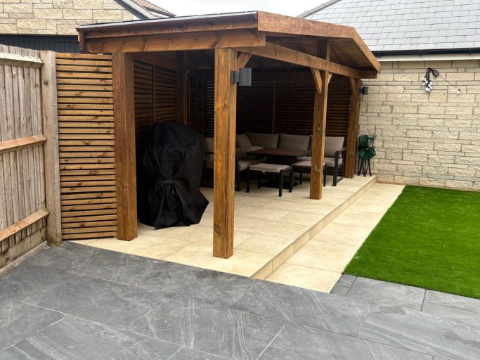 Timber Pergola and Garden Transformation in Weston-Super-Mare Bespoke timber pergola with a covered seating area, porcelain patio and artificial grass in Weston-Super-Mare.