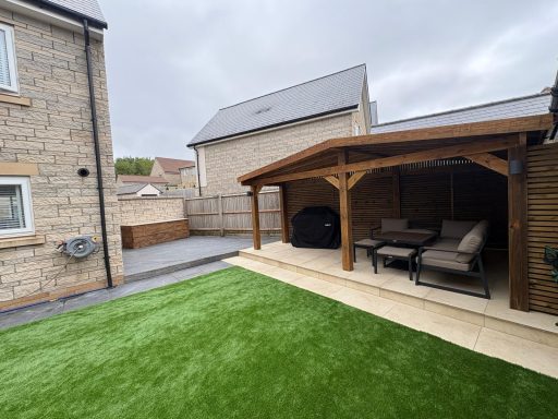 Bespoke timber pergola with a covered seating area, porcelain patio and artificial grass in Weston-Super-Mare.